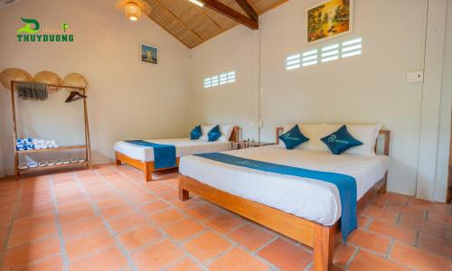 a bedroom with two beds in a room at Homestay Thùy Dương 2 in Cai Be