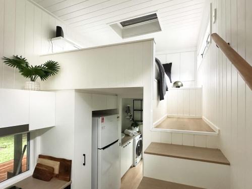 a kitchen with white cabinets and a white refrigerator at Atherton Tiny - Retreat with Fire Pit in Atherton