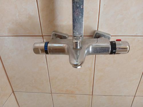 a metal pipe attached to a tiled bathroom wall at Glamping Machupicchu Lodge in Santa Teresa