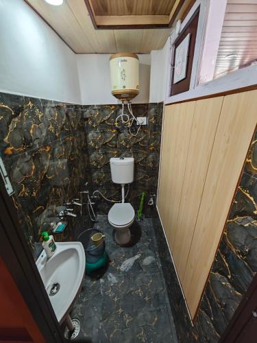 a bathroom with a toilet and a sink at The District Green in Kalpa