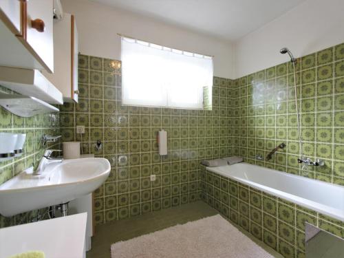 a bathroom with a sink and a bath tub at Chalet in St Johann near Ski Slopes in Alpendorf