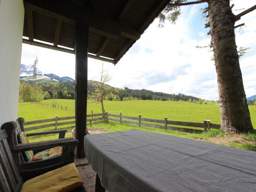 a table on a porch with a view of a field at Chalet in St Johann near Ski Slopes in Alpendorf