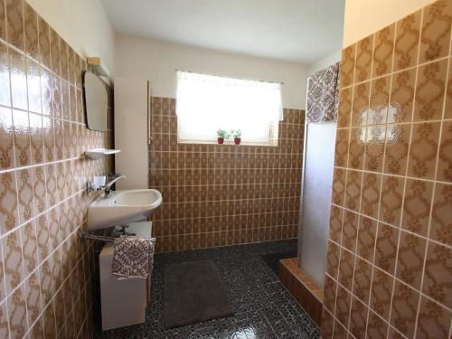 a bathroom with a sink and a shower with a window at Chalet in St Johann near Ski Slopes in Alpendorf