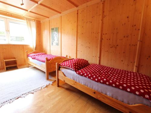 two beds in a room with wooden walls at Chalet in St Johann near Ski Slopes in Alpendorf