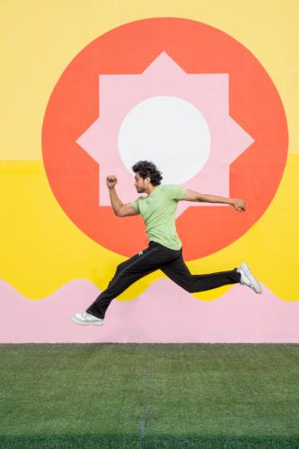 a man jumping in the air in front of a wall at Priya Hyderabad in Hyderabad