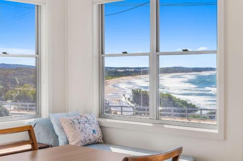 a living room with windows with a view of the beach at Beachview in Bonny Hills