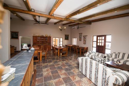a living room with couches and a table and chairs at Foreva Wild in Klipdrift