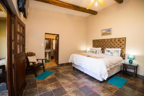 a bedroom with a large bed and a chair at Foreva Wild in Klipdrift