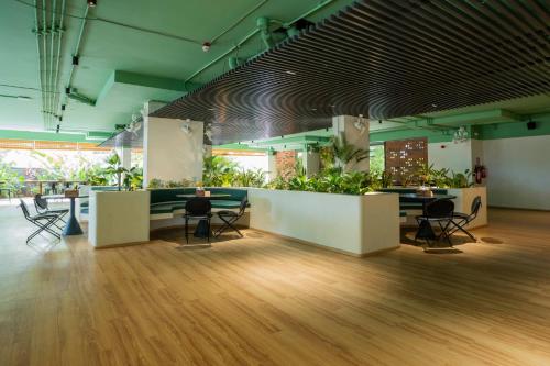 a lobby with tables and chairs and plants at Priya Hyderabad in Hyderabad