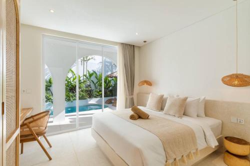 a bedroom with a bed and a large window at Stylish 3BR Villa - Walk to Pererenan Beach in Pererenan