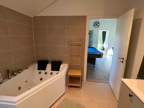 a large bathroom with a tub and a sink at Explore Bay And Nature In Pretty Kostræde Banker in Køng