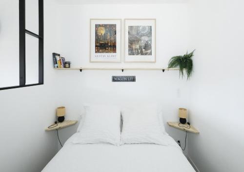 a bedroom with a white bed with two shelves at Breuil Station, studio tout confort in La Mure
