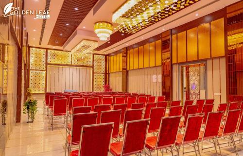 a large room with red chairs in a building at The Golden leaf hotel in Gaya