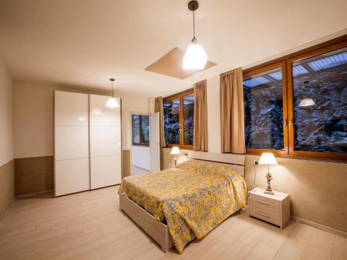 a bedroom with a bed and a large window at Lakeside Mansion with Pool in Artogne
