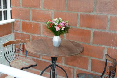 un tavolo con un vaso di fiori sopra di Pousada Ilha Maravilha a Rio de Janeiro