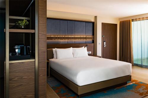 a bedroom with a large white bed and a large window at Hyatt Regency Malta in St Julian's