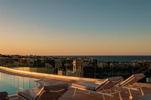 a balcony with chairs and a view of the city at Hyatt Regency Malta in St Julian's