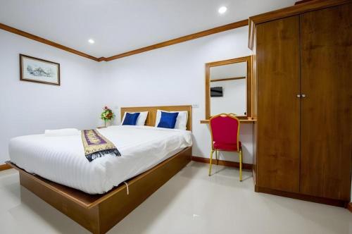a bedroom with a large bed and a red chair at Thatphanom View Hotel Nakhon in Nakhon Phanom