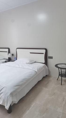 a bedroom with a large white bed and a table at Hongyang Inn Hotel, Lingui District, Guilin in Guilin