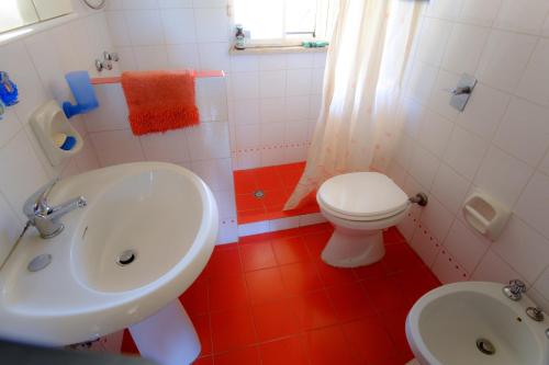a bathroom with a white sink and a toilet at Dalle Grotte al Mare in Fontane Bianche