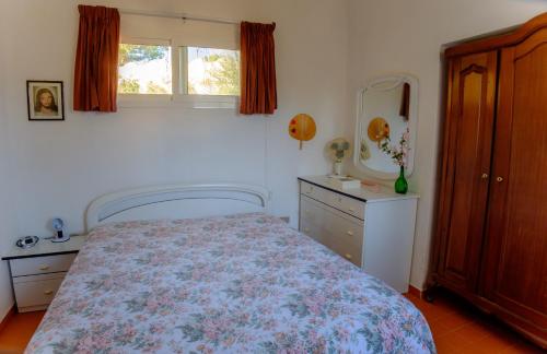 a bedroom with a bed and a dresser and a mirror at Dalle Grotte al Mare in Fontane Bianche