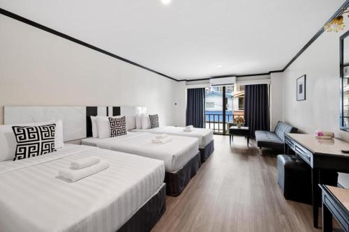 a hotel room with two beds and a desk at Town In Town Gardent Resort in Sathani Khlong Tan