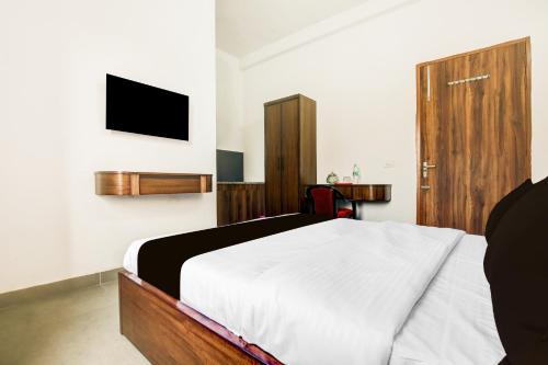a bedroom with a bed and a tv on the wall at Collection O Kalpana Chawla Hospital Karnal in Karnal