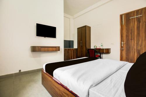 a bedroom with a bed and a flat screen tv at Collection O Kalpana Chawla Hospital Karnal in Karnal