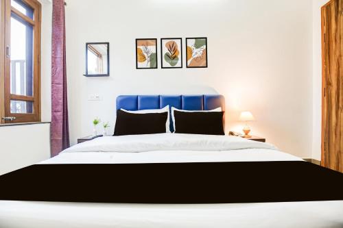 a bedroom with a large bed with a blue headboard at Collection O Kalpana Chawla Hospital Karnal in Karnal