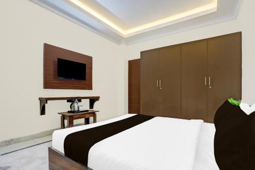 a bedroom with a large bed and a television at Super Townhouse Madiwala Lake Park in Bengaluru