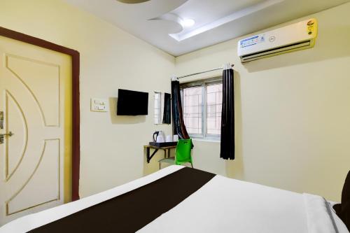 a bedroom with a bed and a window and a door at Super Collection O Gachibowli in Hyderabad