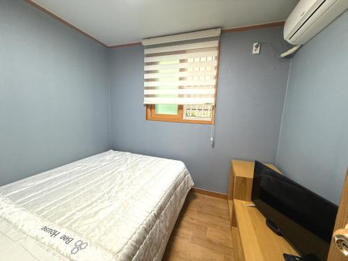 a small bedroom with a bed and a window at Gyeongju Bee House in Gyeongju