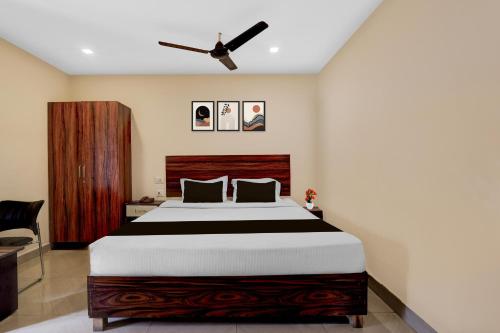 a bedroom with a large bed and a ceiling fan at Super Hotel O Benz Circle Crossway Vijayawada Formerly Akshaya Elite in Vijayawada