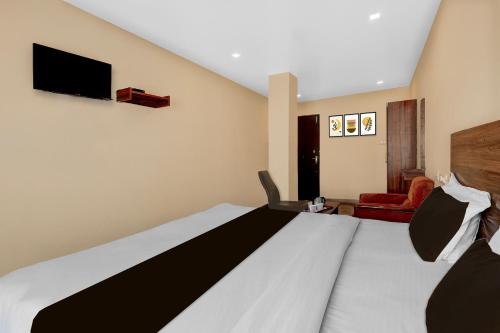 a hotel room with a bed and a tv at Super Hotel O Benz Circle Crossway Vijayawada Formerly Akshaya Elite in Vijayawada