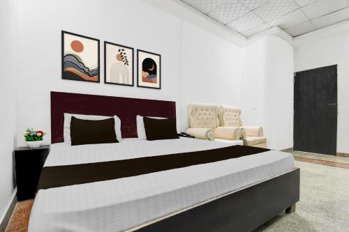 a bedroom with a large bed and a chair at Collection O Vrindavan Yojna Lucknow Formerly Khushboo Palace in Nilmatha