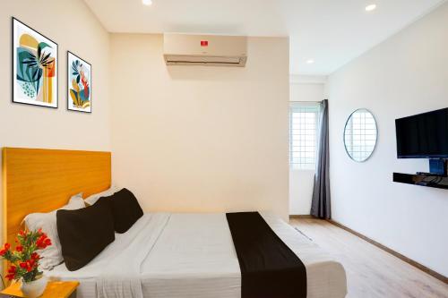 a bedroom with a bed and a flat screen tv at Townhouse Sarjapur Road Formerly Hotel Ace in Bengaluru