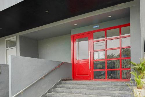 a red door on a house with stairs at Townhouse Sarjapur Road Formerly Hotel Ace in Bengaluru