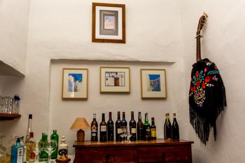 a bunch of bottles on a bar with pictures on the wall at Hotel Los Castaños in Cartajima