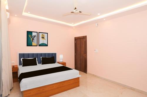a bedroom with a bed and a ceiling fan at Super Townhouse Tender Village Formerly Seven Seas in Rātu