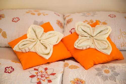 two orange pillows with bows on them on a bed at Accommodation Resman in Bohinj