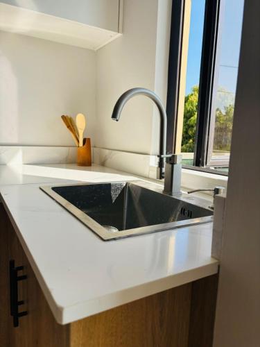a kitchen counter with a sink and a window at Cozy 1 bedroom Apartment 6 Min Walk to Beach in Flic-en-Flac