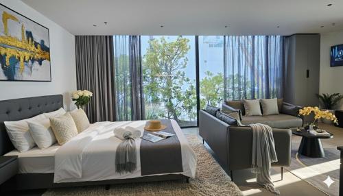 JBAY Beachfront Boutique Hotel في دا نانغ: غرفة نوم بها سرير وأريكة