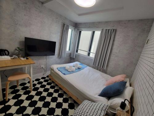 a bedroom with a bed and a desk and a television at ajito s11 市電駅徒歩1分 AC,wifiあり in Sapporo