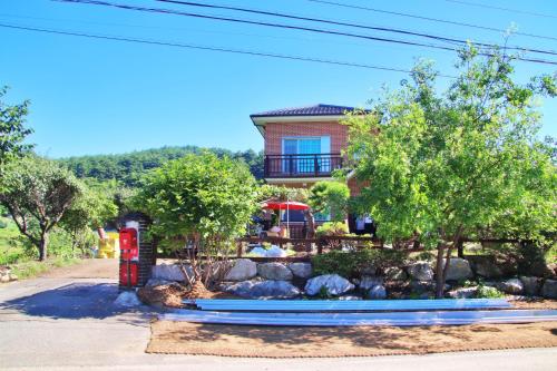 a house with a red telephone booth in front of a yard at U&i펜션 in Yangyang