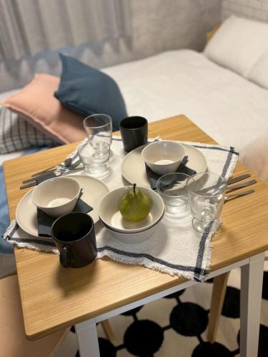 a table with plates and bowls and a p pear on it at ajito s11 市電駅徒歩1分 AC,wifiあり in Sapporo