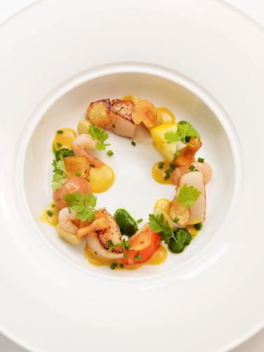 a white plate of food with shrimp and vegetables at Hotel Villa Anna in Uppsala