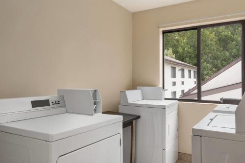 a room with white washing machines and a window at Baymont by Wyndham Branford/New Haven in Branford