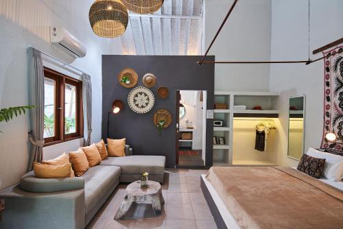 una sala de estar con un sofá y una mesa en Lila Boutik Residence, en Canggu