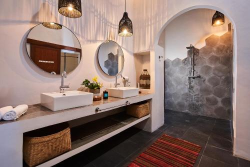 un baño con dos lavabos y dos espejos en Lila Boutik Residence, en Canggu