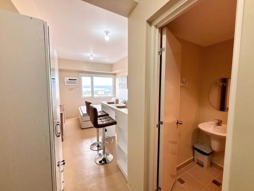 a bathroom with a sink and a desk with a chair at Heart of CDO Scenic View in Cagayan de Oro